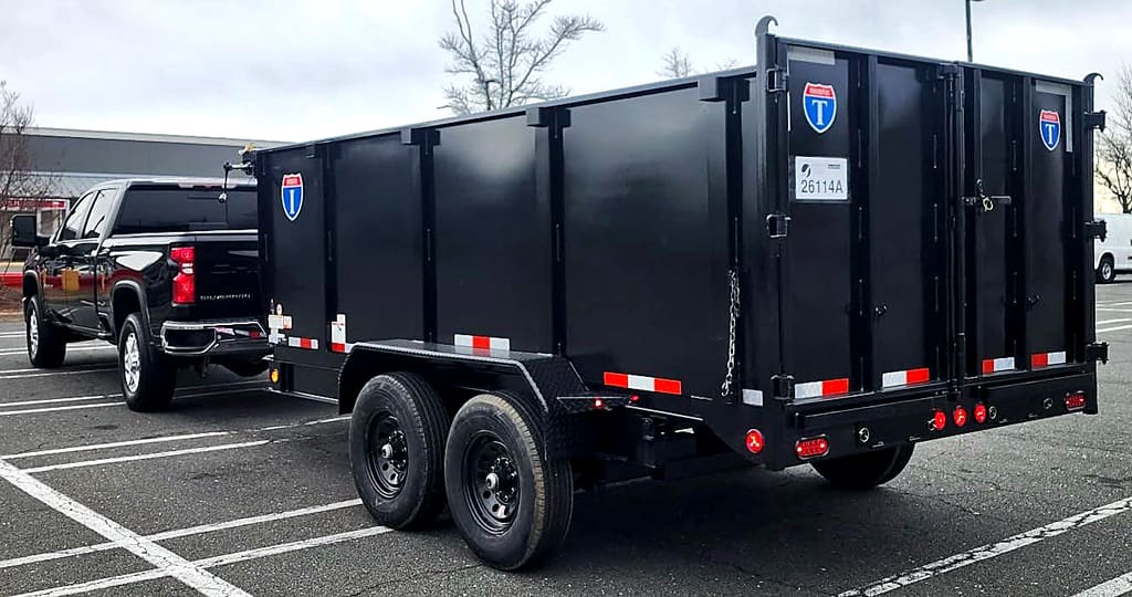 The black Silverado and Brunalli dump trailer in a parking lot