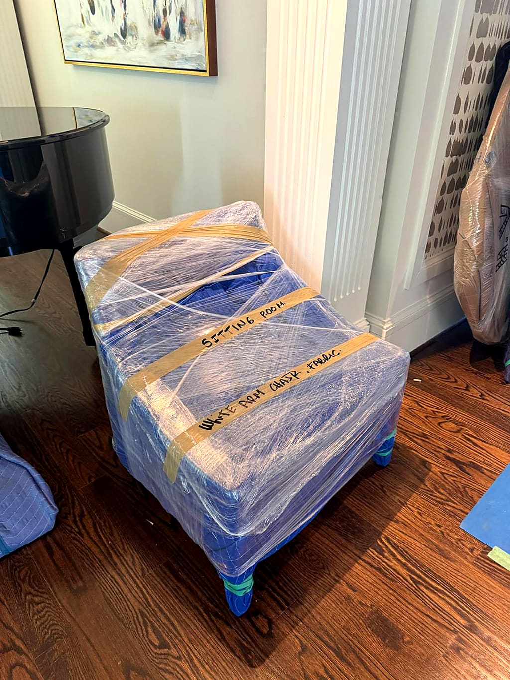 Wrapped ottoman with handwritten labels on the tape