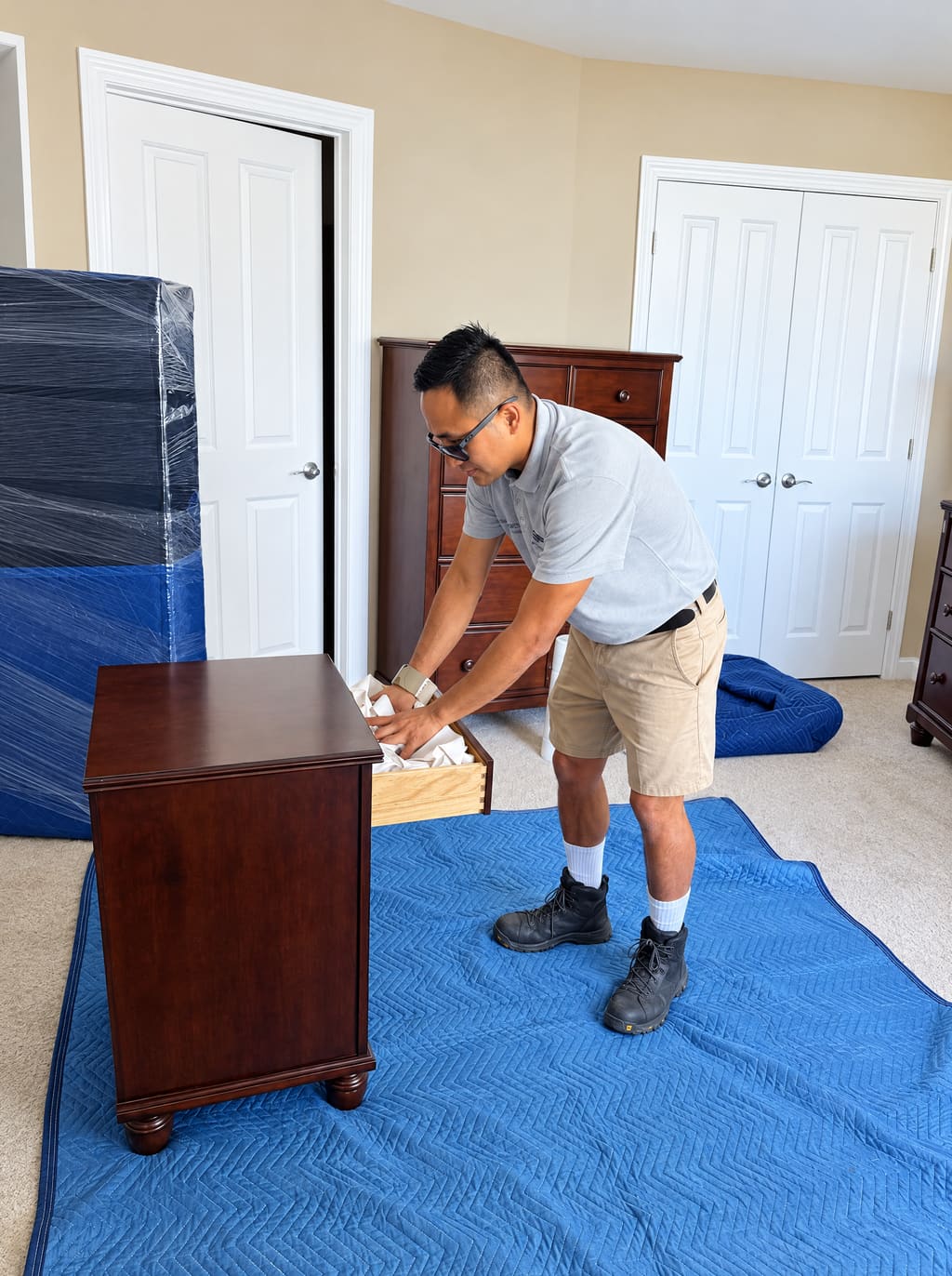 Luis padding a nightstand on a blue moving pad